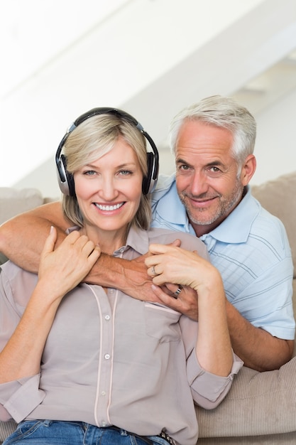 Mature man embracing woman from behind on sofa