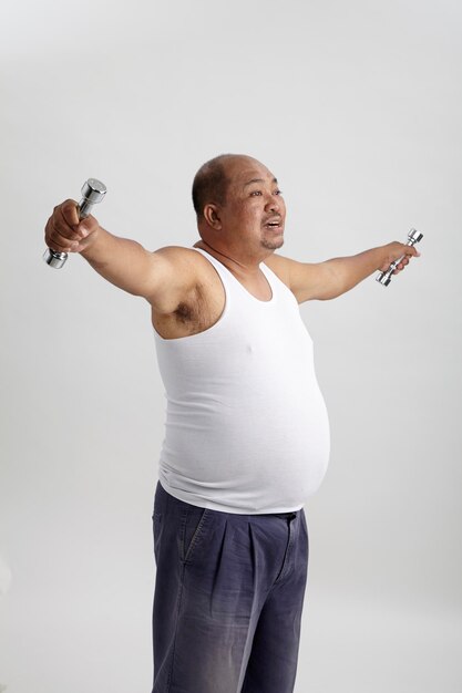 Photo mature man exercising with dumbbells against white background