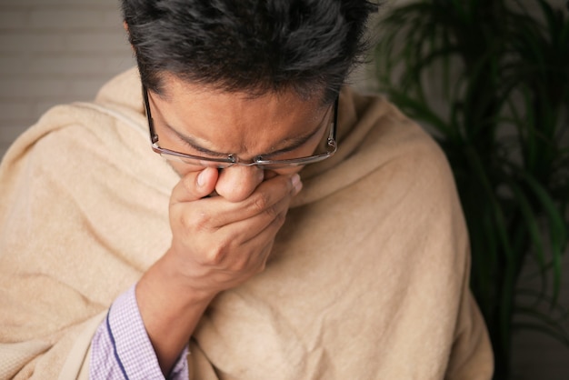 Mature man felling sick and coughs at home