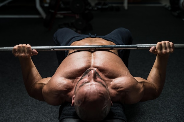 Mature Man In Gym Exercising On The Bench Press