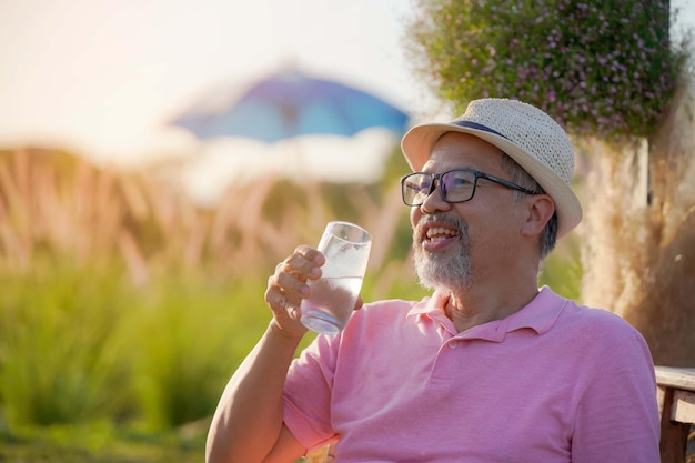 Mature The man has a gray beard.
Sit down and drink a glass of water with a happy smiling face.