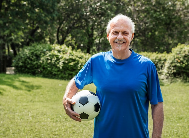 Uomo maturo che tiene un calcio