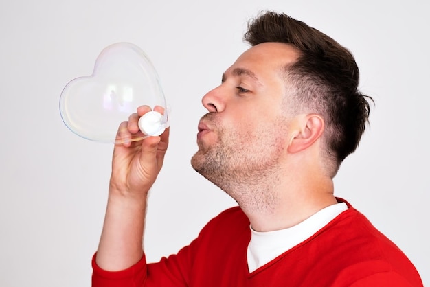 Un uomo maturo gonfia le bolle di sapone come un bambino