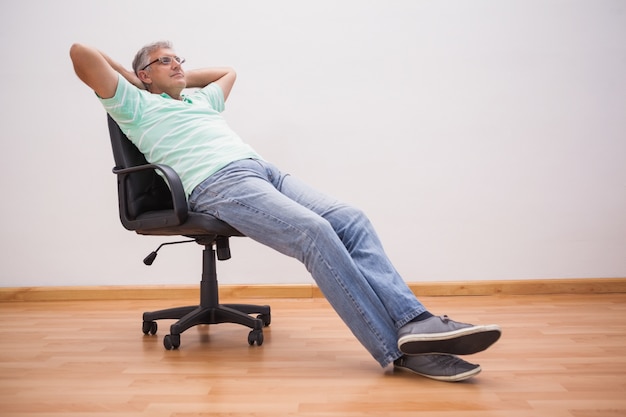 Mature man leaning back in swivel chair