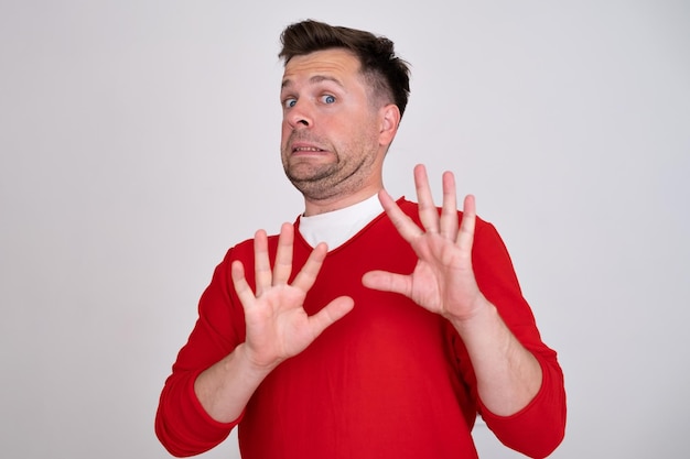 Mature man looking serious showing open palm making stop gesture