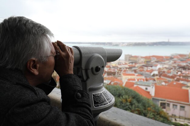 Foto uomo maturo che guarda con il binocolo