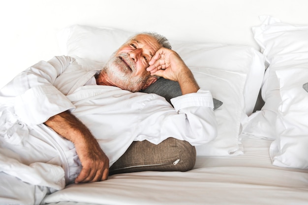 Mature man lying on a bed