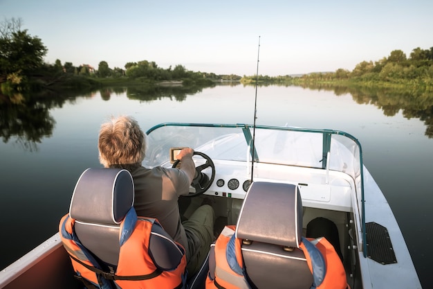 Uomo maturo su una barca a motore. pesca.