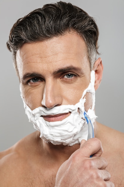 Mature man naked shaving.