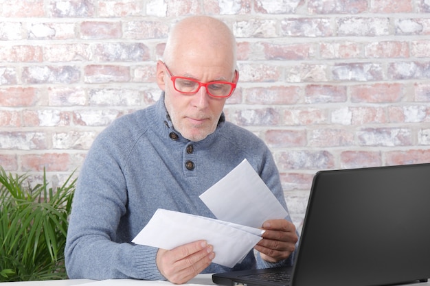 Mature man opening letter envelope