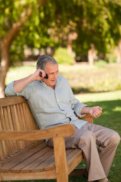 Uomo maturo che telefona nel parco