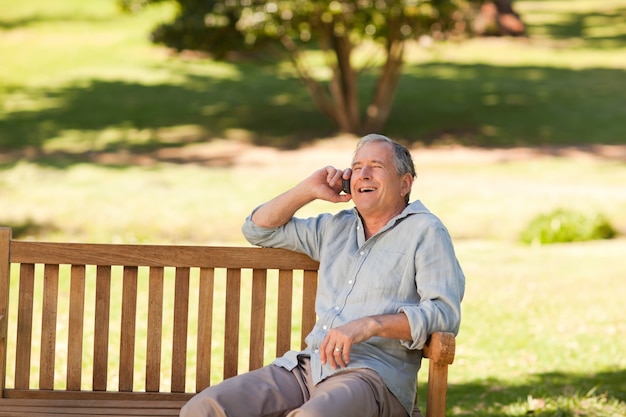 Mature man phoning in the park