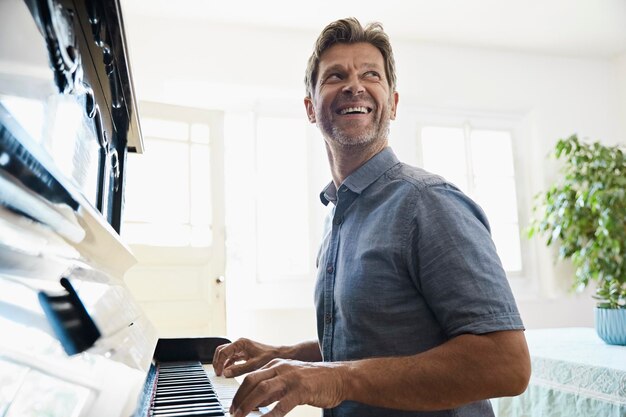 Mature man playing piano at home