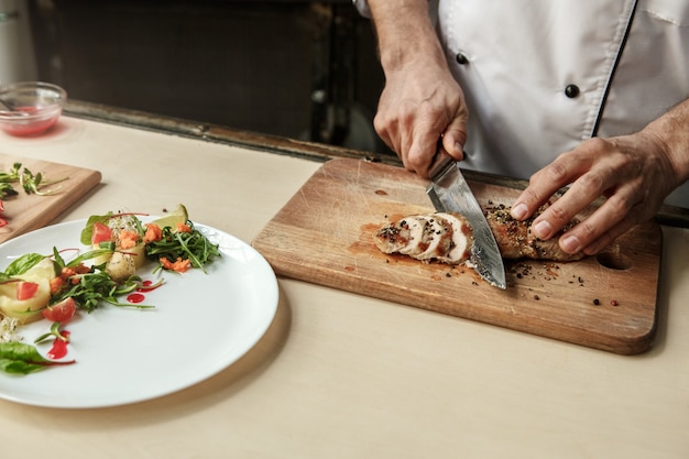 Mature man professional chef cooking meal indoors