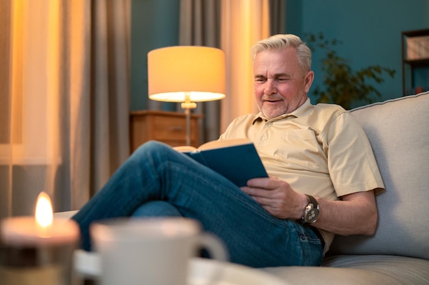 A mature man relaxes on the living room couch at the coffee table with a mug of coffee tea