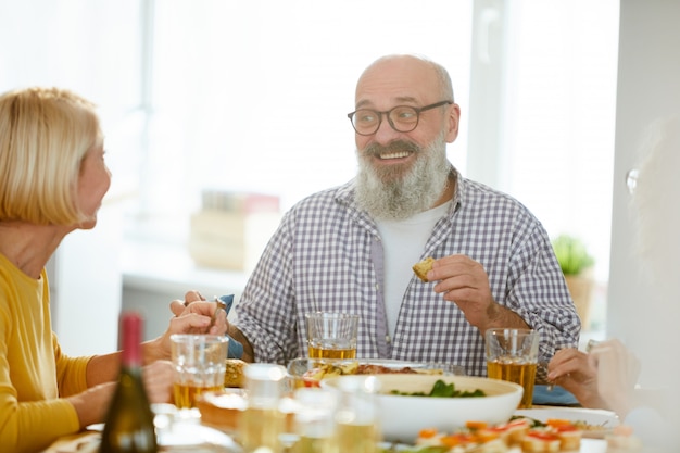 Mature man sharing expressions from dinner with wife