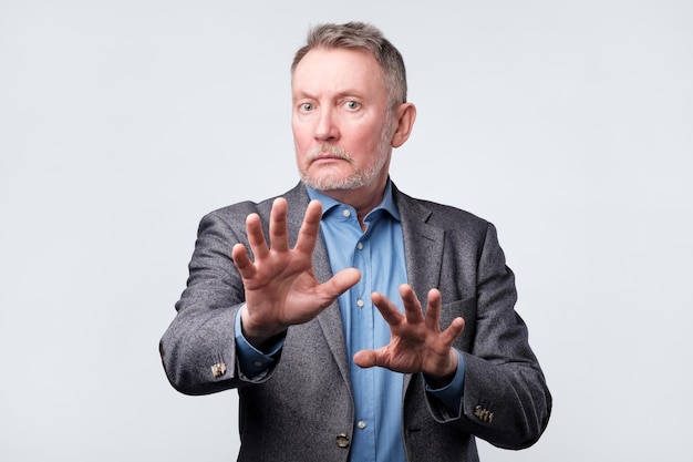 Mature man showing refusal sign It is not for me