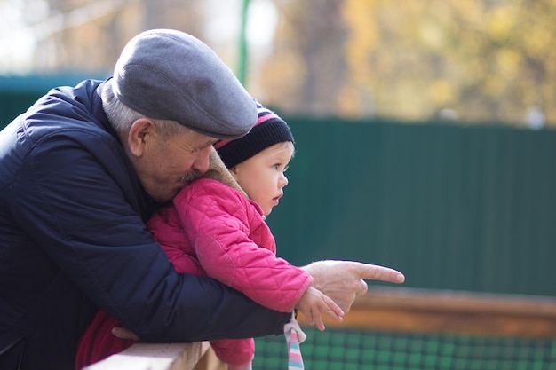 Mature man showing at something little girl outside