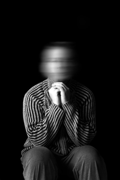 Mature man sitting against black background