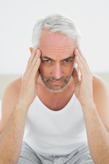 Mature man suffering from headache in bed