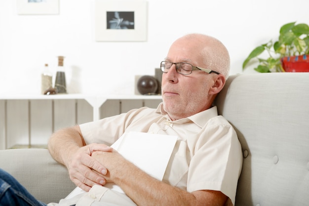 Mature man taking a nap in sofa at home