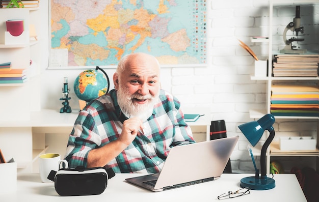 Mature man teacher on balckboard background old teacher loves smiles