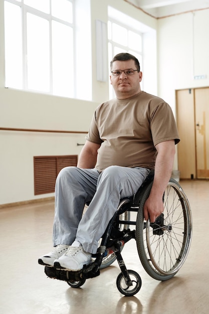 Зрелый мужчина в инвалидном кресле в танцевальной студии