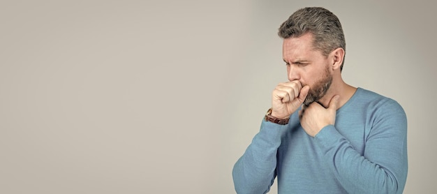 mature man with beard has cough suffer from sore throat on grey background mens health man face portrait banner with copy space