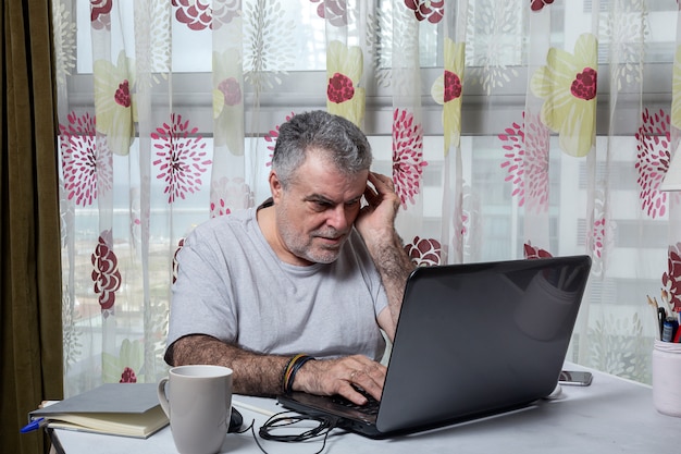 Mature man with a beard working at home