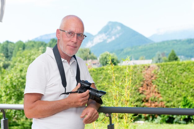 mature man with dslr camera outdoors