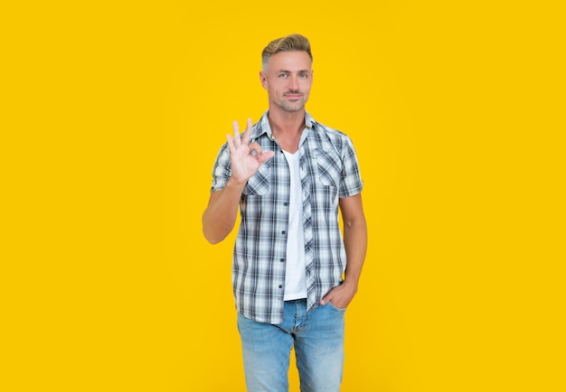 Mature man with grizzle hair on yellow background ok