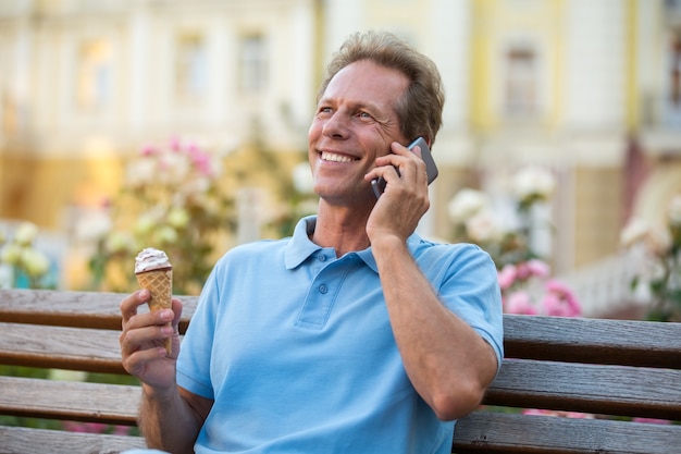 Mature man with phone smiling.