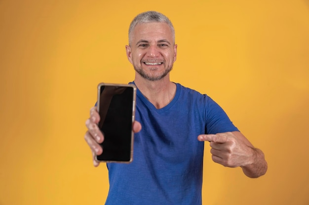 Mature man with a smartphone with blank screen with free space for text