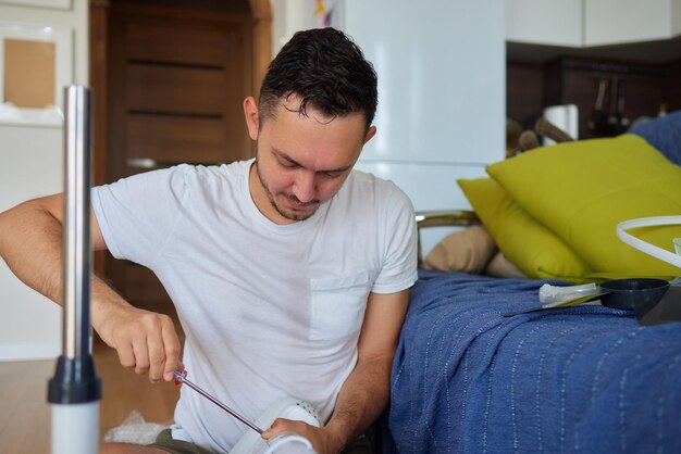 Mature man works to install a paddle fan on the ceiling at home