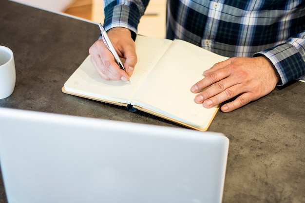 Photo mature man writting notes on blank paper