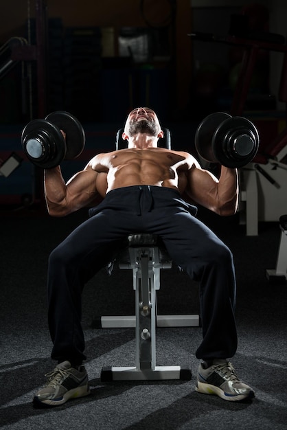 Mature Men Doing Dumbbell Incline Bench Press Workout In Gym