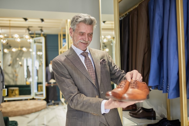 Mature millionaire selects new shoes in an exclusive boutique.