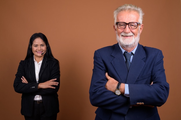 Mature multi-ethnic business couple on brown