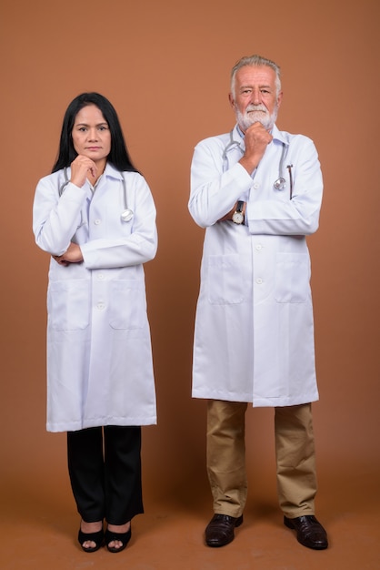 Mature multi-ethnic couple doctors on brown