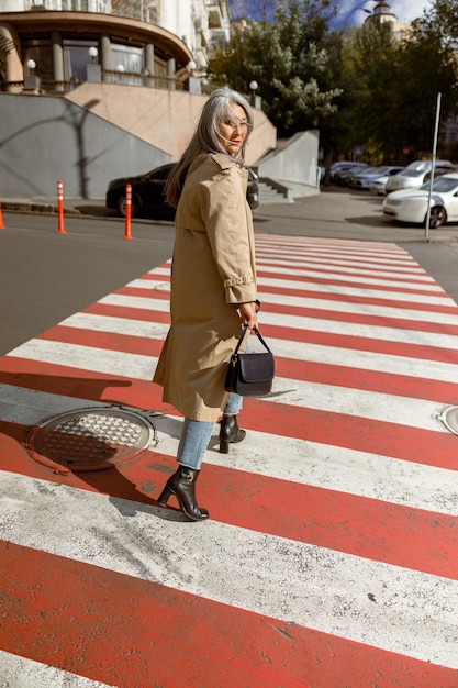 Foto ritratto di stile di vita di donna alla moda capelli pallidi matura all'aperto in città