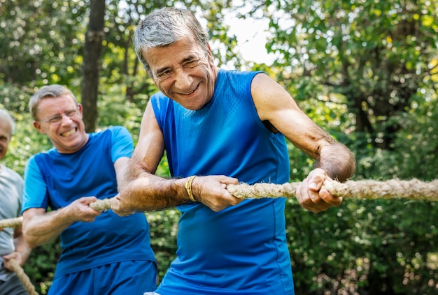 Photo mature people in tug of war