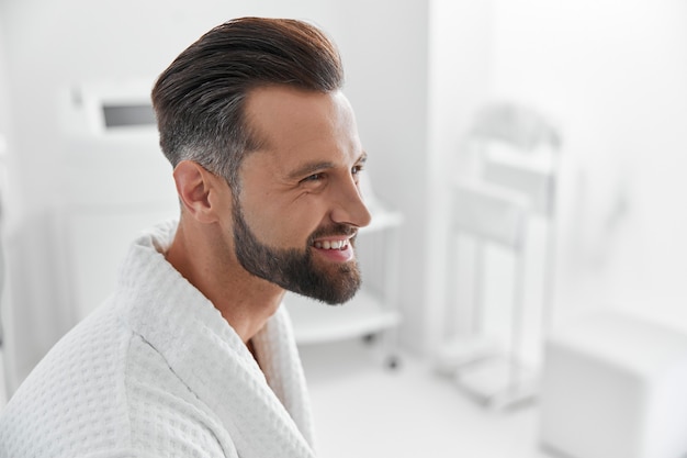 Mature person wearing bathrobe waits for skin care procedures in salon