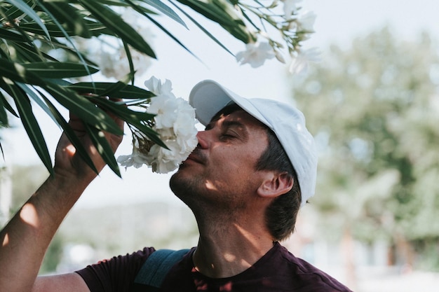 Mature real candid man traveler enjoys the scent of a flowers in hand holding on a summer journey everyday moment concept of stereotypesfree positive masculinity and male mental and emotional health