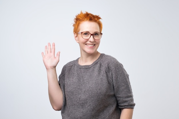 Mature redhead woman in a gray blouse