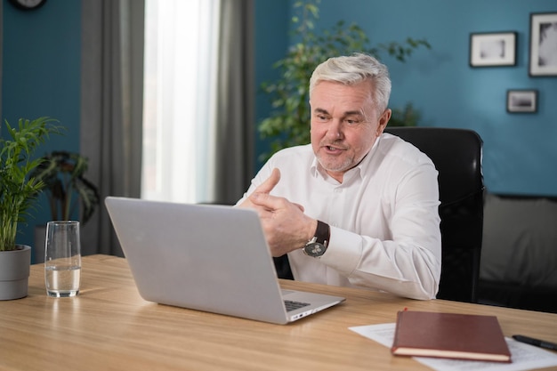 Mature s couple in separation talk during virtual meeting by video call grey haired husband enjoy co