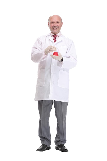 Mature scientist with grey hair and beard in white coat standing with beaker in his hand and holding...