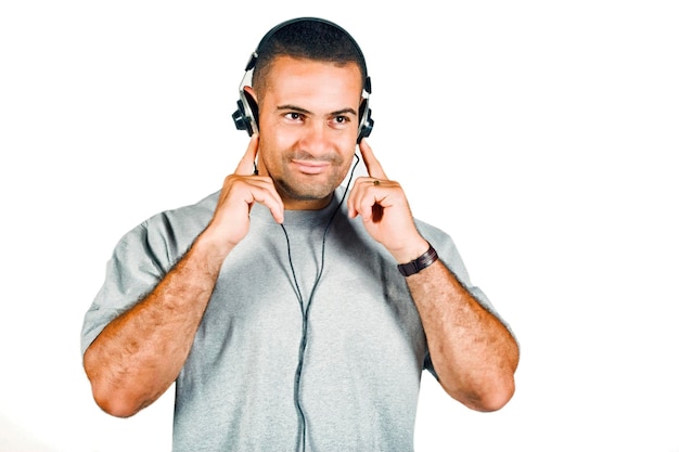 Mature smiling man listening music against white background