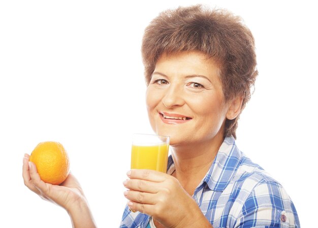 Foto donna sorridente matura con succo d'arancia