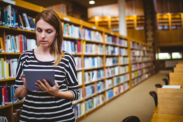 Mature student in the library using tablet