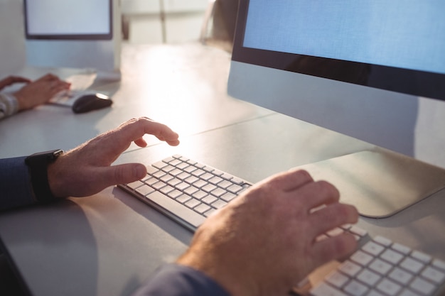 Foto studente maturo che per mezzo del computer